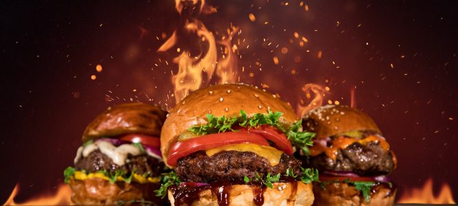 Game Day Burgers with Homemade Barbecue Sauce – Winter Game Day Series Close-up of home made tasty burger with french fries and fire flames.